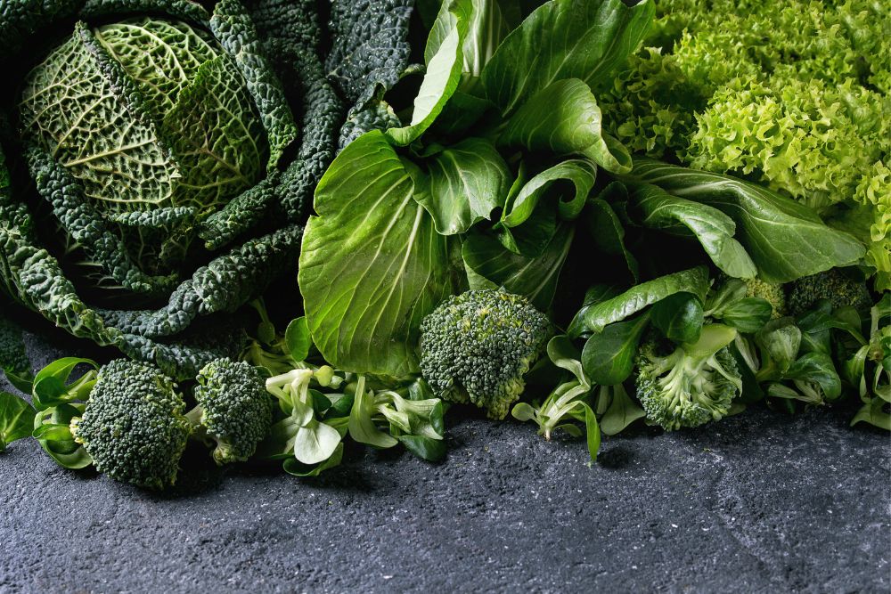 Gr&uuml;nes Gem&uuml;se, darunter Kohl, Brokkoli und Feldsalat, auf einem Tisch