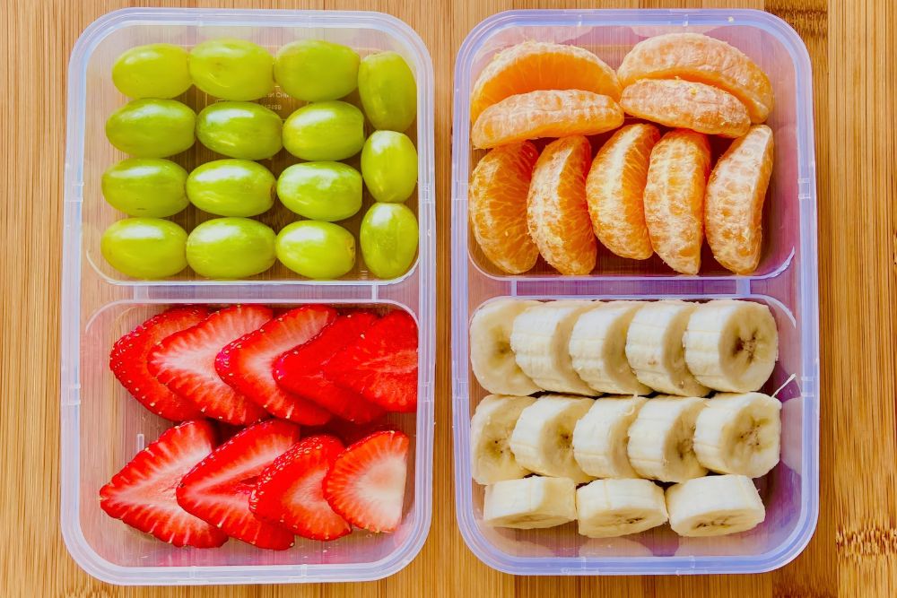 Boxen mit Bananen, Trauben, Erdbeeren und Mandarinenst&uuml;ckchen