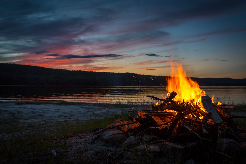 Ein Lagerfeuer am See bei D&auml;mmerung