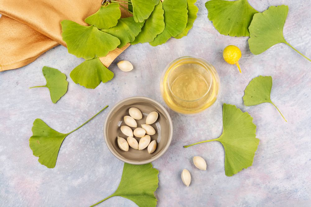 Ginkgo-Bl&auml;tter, Ginkgo-Samen und Ginkgo&ouml;l auf einem Tisch