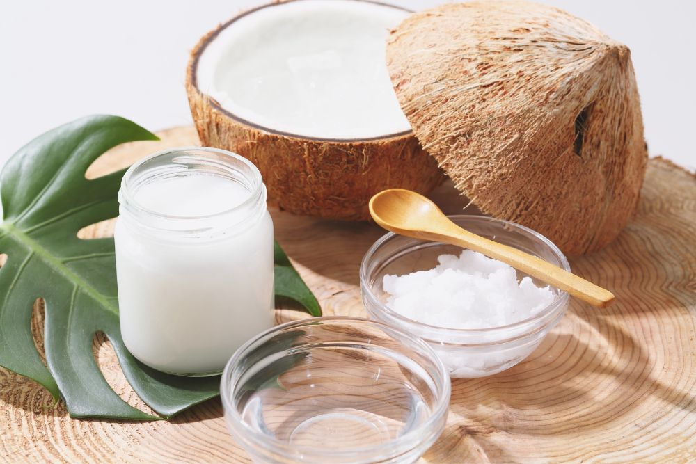 Eine Kokosnuss, eine Schale und ein Glas mit Kokos&ouml;l