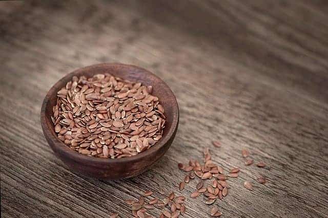 Leinsamen in einer kleinen Holzschale auf Holztisch