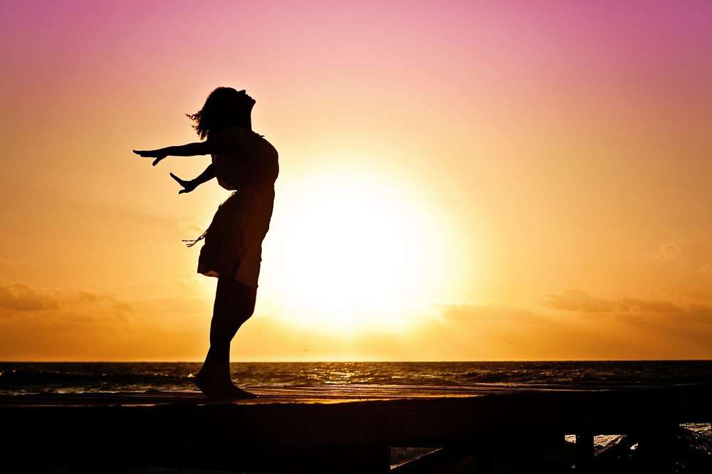 Frau am Meer bei Sonnenuntergang