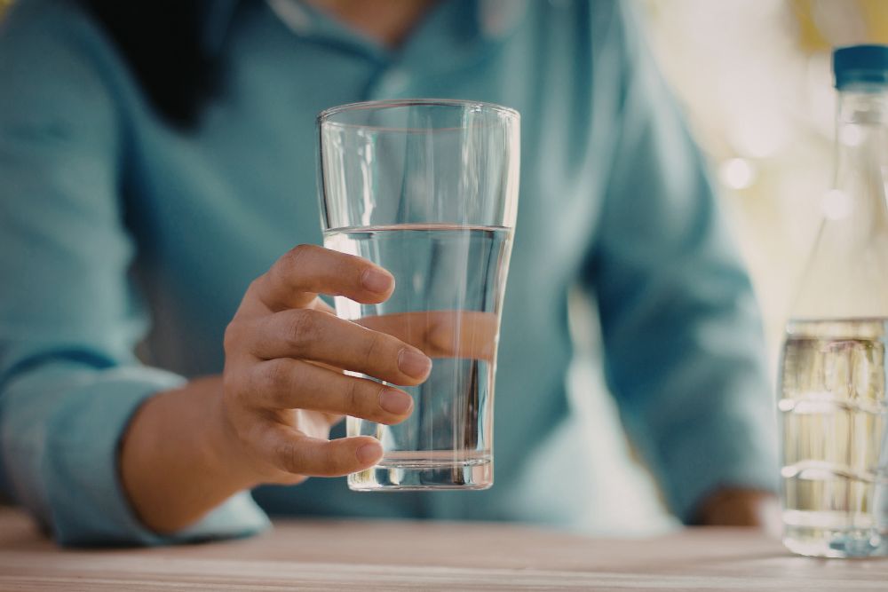 Eine Person trinkt ein Glas Wasser